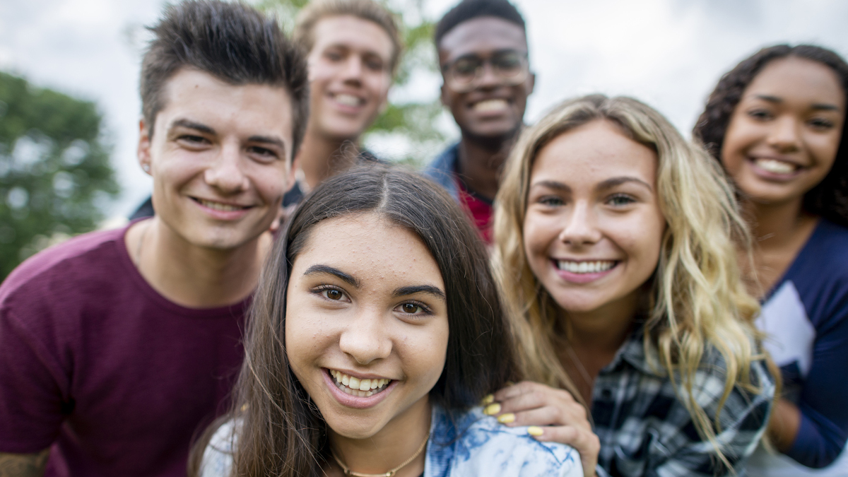 Eine Gruppe aus sechs jungen Menschen steht lächeln zusammen.