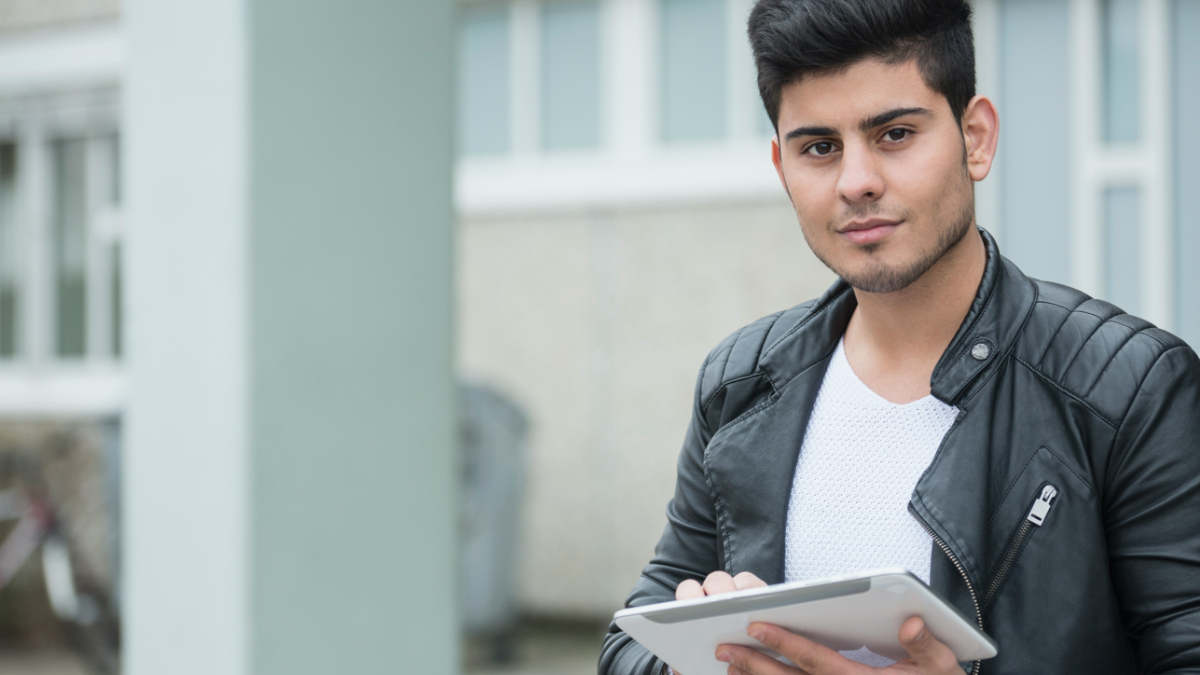 A young man is holding a tablet.  (Source: gettyimages | Niedring|Drentwett) A young man is holding a tablet.